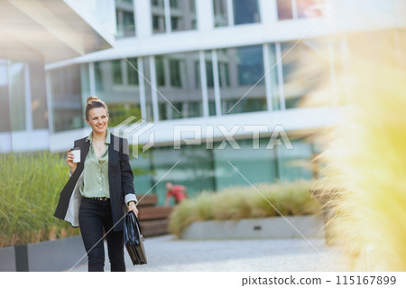 smiling woman employee in business district walking smiling woman employee in business district walking 115167899
