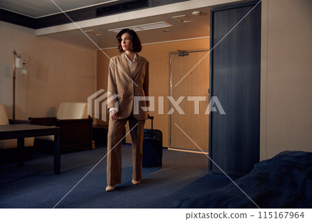 Beautiful stylish businesswoman with luggage suitcase in hotel room Beautiful stylish businesswoman with luggage suitcase in hotel room 115167964