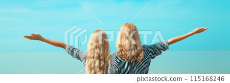Two women together, happy girlfriends or mother with adult daughter on sea together blue sky 115168246