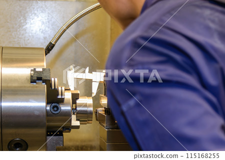 Close up scene the machine operator measuring dimension of turning parts by Vernier caliper. Close up scene the machine operator measuring dimension of turning parts by Vernier caliper. 115168255