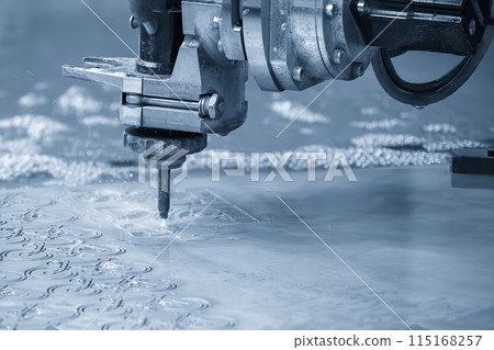 Close-up scene of multi-axis abrasive waterjet cutting machine cutting the aluminum plate. Close-up scene of multi-axis abrasive waterjet cutting machine cutting the aluminum plate. 115168257