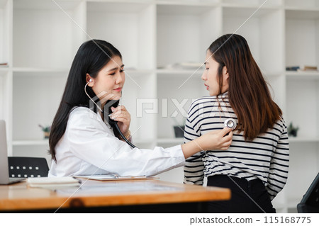 Female doctor using stethoscope to examine patient in modern medical office, focusing on healthcare and patient care. Female doctor using stethoscope to examine patient in modern medical office, focusing on healthcare and patient care. 115168775