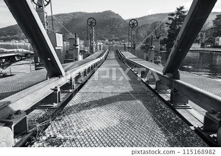 An abandoned metal pier for reloading cargo delivered by water Focus in the middle of the frame Black and white horizontal photo 115168982
