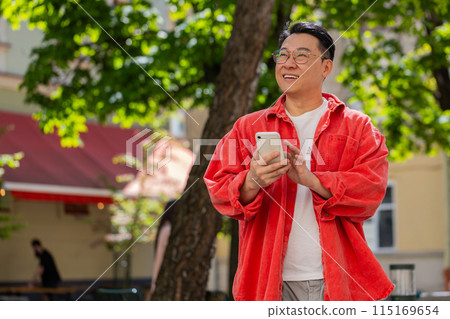 Asian middle-aged man using smartphone typing text messages in social media application online Asian middle-aged man using smartphone typing text messages in social media application online 115169654