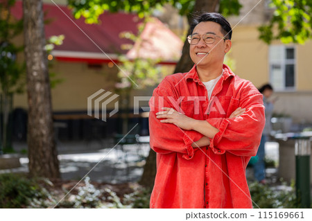 Happy Asian man smiling looking at camera dreaming resting good news feel satisfied in city street Happy Asian man smiling looking at camera dreaming resting good news feel satisfied in city street 115169661