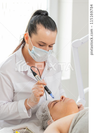 Cosmetologist doing peeling procedure, woman skin regeneration, dermapen microneedling, dermastamp 115169784