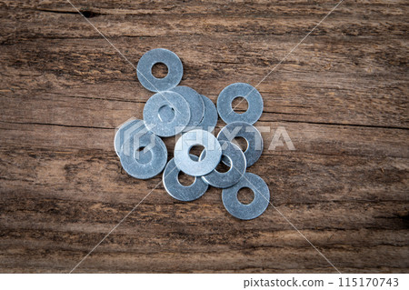 Bunch of flat washer on a dark wood texture background 115170743