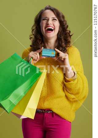 happy healthy woman in yellow sweater isolated on green happy healthy woman in yellow sweater isolated on green 115170767