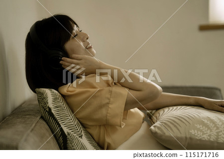 A woman listening to music with headphones A woman listening to music with headphones 115171716