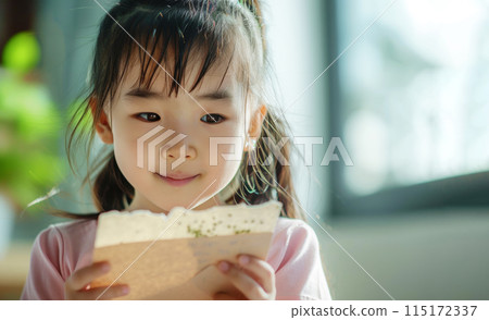 A Generation Alpha girl engages with plantable seed paper, a hands-on learning experience about growth and sustainability. 6 years old kid with sustainability biodegradable greeting card 115172337