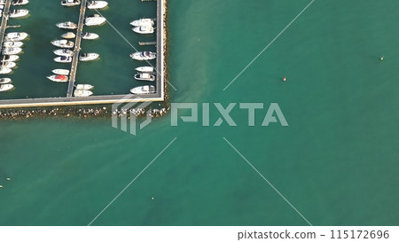 Italy, Peschiera del Garda, Lake Garda - Aerial view of the port of Lake Como. Yacht Club. Moored yachts and motorized private boats. The pier is made of wood. Beautiful clear water. Italy, Peschiera del Garda, Lake Garda - Aerial view of the port of Lake Como. Yacht Club. Moored yachts and motorized private boats. The pier is made of wood. Beautiful clear water. 115172696