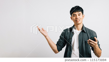 Portrait Asian smiling young man holding mobile phone and hand open to empty space studio shot isolated white background, Happy excited lifestyle men hold smartphone present something on palm 115173894