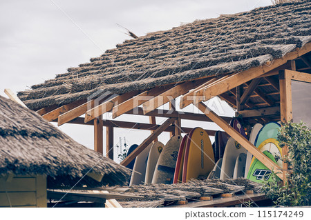 An image of the thatched roof of a wooden hut showing the storage room for a surfboard. With space to copy. High quality photo 115174249