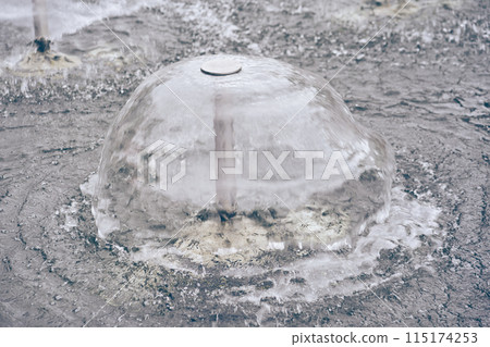 A close-up of a metal structure, in the center of which transparent water forms a small fountain. With space to copy. High quality photo A close-up of a metal structure, in the center of which transparent water forms a small fountain. With space to copy. High quality photo 115174253