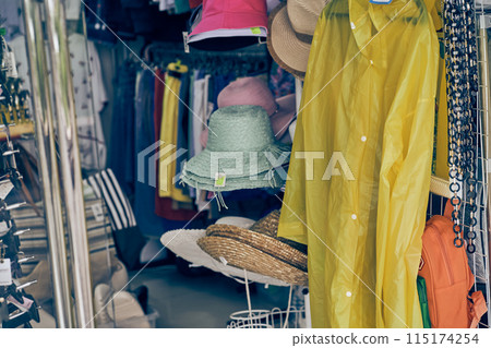 A room with summer season clothes without people. In the foreground is a yellow raincoat. The concept of outdoor shopping. High quality photo A room with summer season clothes without people. In the foreground is a yellow raincoat. The concept of outdoor shopping. High quality photo 115174254