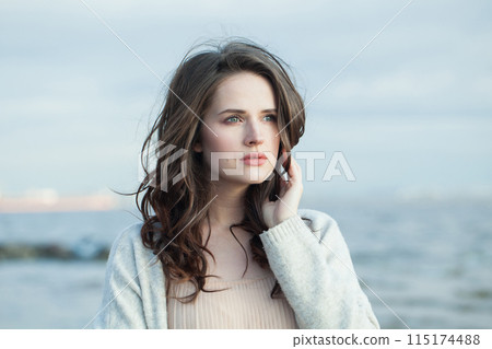 Pensive brunette woman with fresh skin, natural make-up and healthy wavy brown hair Pensive brunette woman with fresh skin, natural make-up and healthy wavy brown hair 115174488