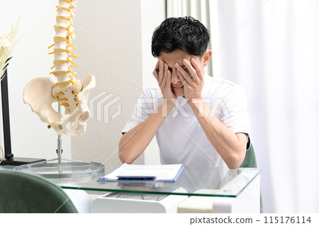 Asian male medical worker holding his head Asian male medical worker holding his head 115176114