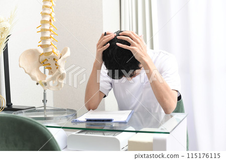 Asian male medical worker holding his head Asian male medical worker holding his head 115176115