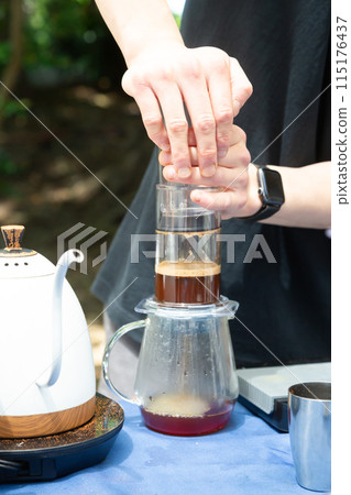 Hands of a man brewing coffee at a coffee stand Hands of a man brewing coffee at a coffee stand 115176437