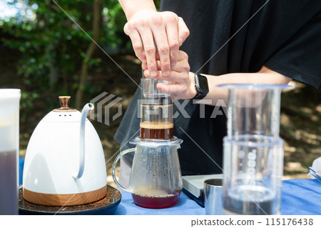 Hands of a man brewing coffee at a coffee stand Hands of a man brewing coffee at a coffee stand 115176438