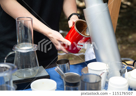 A man's hands grinding coffee beans at a coffee stand 115176507