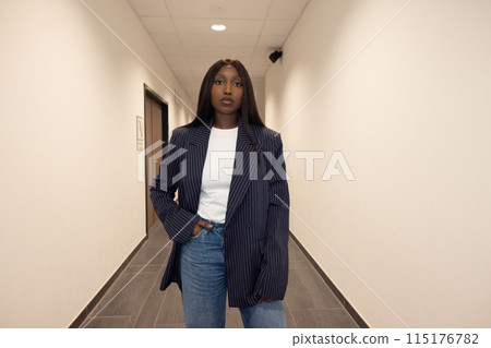 Confident woman in blazer and jeans showcases a chic professional look with a contemporary touch Confident woman in blazer and jeans showcases a chic professional look with a contemporary touch 115176782