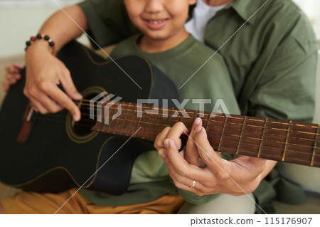 Father Teaching Son Playing Guitar Father Teaching Son Playing Guitar 115176907
