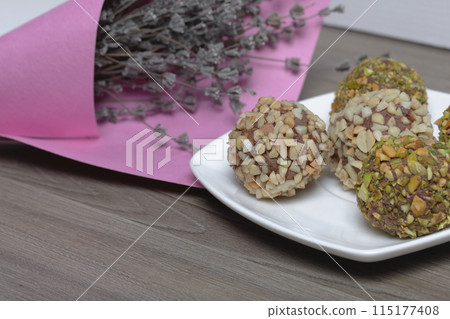 Homemade sweets. Chocolate truffles with a crumb of peanuts and pistachios. 115177408