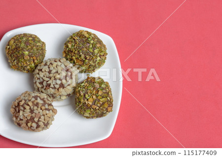 Homemade sweets. Chocolate truffles with a crumb of peanuts and pistachios. 115177409