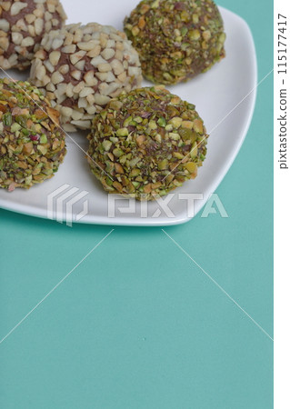 Homemade sweets. Chocolate truffles with a crumb of peanuts and pistachios. 115177417