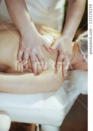 Closeup on massage therapist in spa salon do massage therapy Closeup on massage therapist in spa salon do massage therapy 115178159