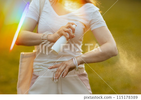 Closeup on female in white shirt with tote bag and spf 115178389