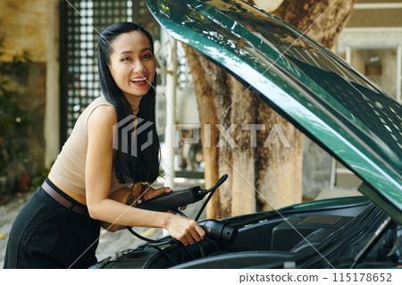 Woman Putting Cable in Trunk 115178652