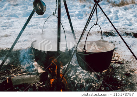 The food is cooked in two pots over a fire The food is cooked in two pots over a fire 115178797