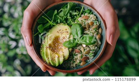 Person Holding Bowl of Quinoa, Avocado, and Greens 115178899