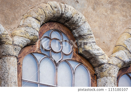 Gothic window with wooden frame in stone wall Gothic window with wooden frame in stone wall 115180107
