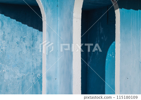 Blue and white grungy concrete arch, old exterior details, abstract photo 115180109