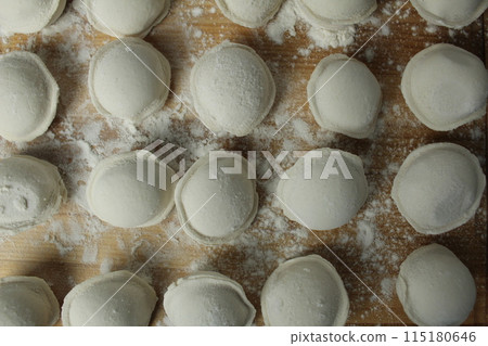 Close-up of frozen dumplings on a blackboard. Background of food. National traditional dishes Close-up of frozen dumplings on a blackboard. Background of food. National traditional dishes 115180646