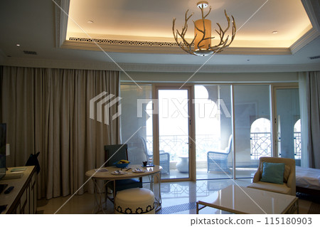 RAS AL KHAIMAH, UNITED ARAB EMIRATES - JUN 11, 2019: Luxurious hotel room with view from the living area to the large balcony in a five star hotel 115180903