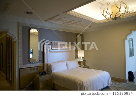RAS AL KHAIMAH, UNITED ARAB EMIRATES - JUN 11, 2019: King-size bed in a luxurious hotel room in a five star hotel RAS AL KHAIMAH, UNITED ARAB EMIRATES - JUN 11, 2019: King-size bed in a luxurious hotel room in a five star hotel 115180934