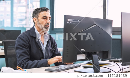 Businessman using computer at desk in creative workspace 115181489