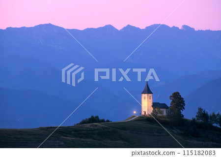 Church on a hill at dusk with mountain ranges in the background 115182083