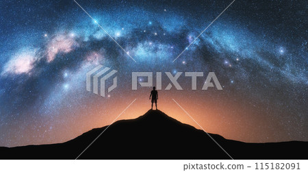 Milky Way and sporty man on mountain peak at starry night 115182091