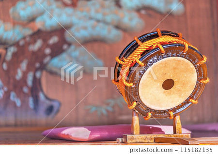 [Domestic] A shime-daiko drum placed on a stand in front of a mural of a pine tree. 115182135