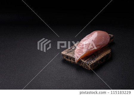 Fresh chicken fillet on a dark concrete table with spices and herbs Fresh chicken fillet on a dark concrete table with spices and herbs 115183229