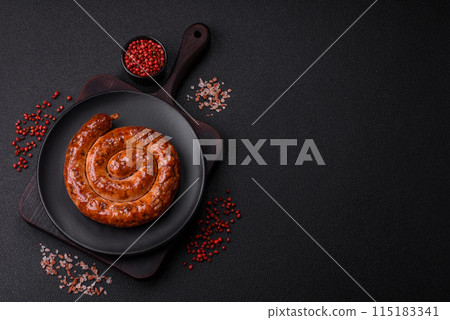 Delicious homemade sausage in the form of a spiral baked on the grill with salt, spices Delicious homemade sausage in the form of a spiral baked on the grill with salt, spices 115183341