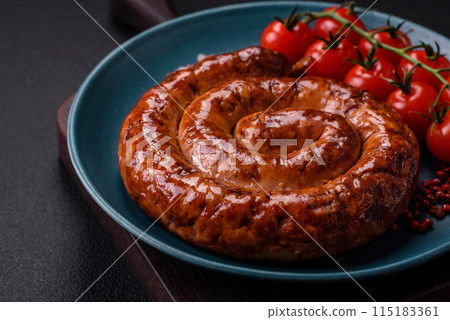 Delicious homemade sausage in the form of a spiral baked on the grill with salt, spices Delicious homemade sausage in the form of a spiral baked on the grill with salt, spices 115183361