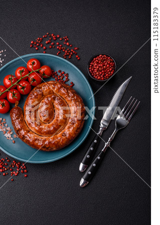 Delicious homemade sausage in the form of a spiral baked on the grill with salt, spices 115183379