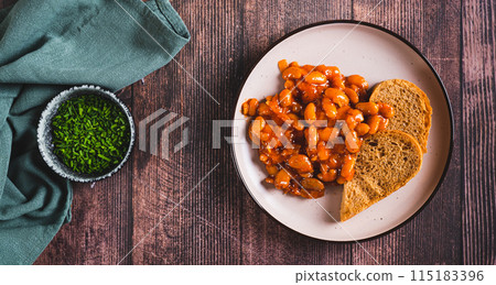 Plate with baked beans in tomato sauce and rye bread on the table top view web banner Plate with baked beans in tomato sauce and rye bread on the table top view web banner 115183396