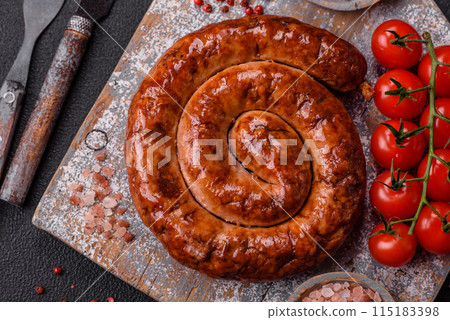 Delicious homemade sausage in the form of a spiral baked on the grill with salt, spices Delicious homemade sausage in the form of a spiral baked on the grill with salt, spices 115183398